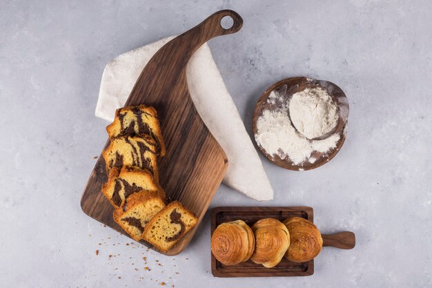 Variety of pastries and buns on a wooden board