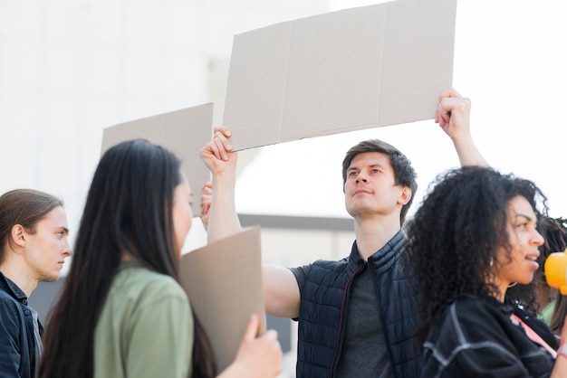 Variety of people protesting in the streets holding cardboards