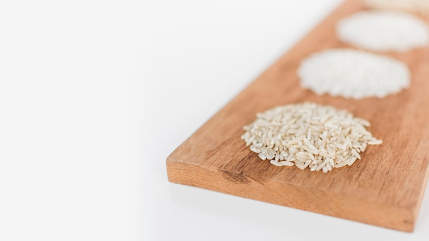 Variety of rice on wooden tray over white background