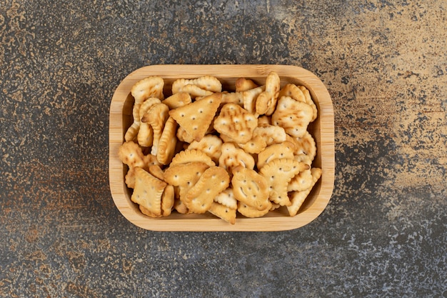 Variety of salted crackers in wooden bowl. 