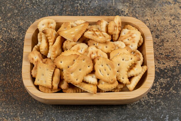 Variety of salted crackers in wooden bowl. 