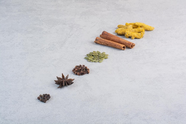 Variety of spices and herbs isolated on concrete background.