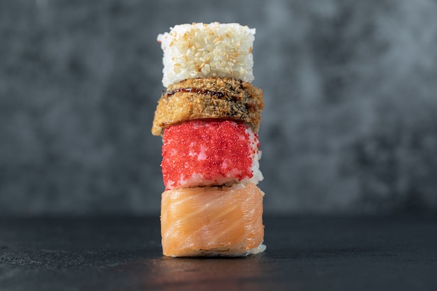 Variety of sushi rolls isolated on grey table.