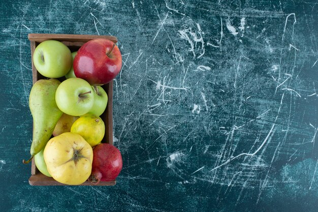 Variety of tasty fruits in wooden box. 