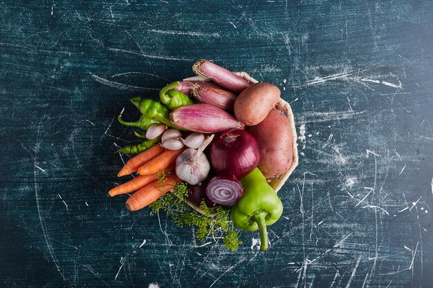 Variety of vegetables isolated on blue table, top view.