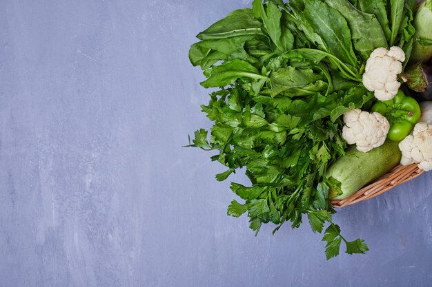 Variety of vegetables on a wooden board on blue