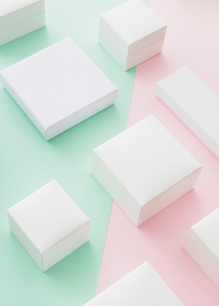 Variety of white boxes on pink and green paper background