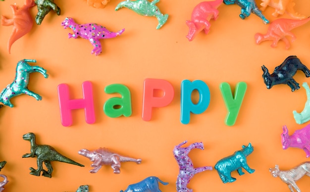 Foto gratuita varia priorità bassa di figure del giocattolo animale con la parola felice
