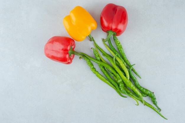 Various bell and chili peppers on blue surface.