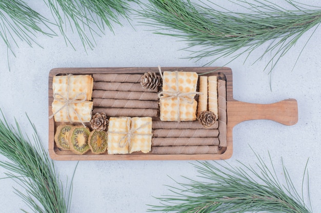 Foto gratuita vari biscotti e fette di kiwi secchi su tavola di legno.