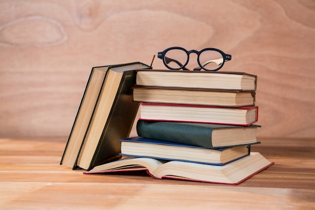 Various books with spectacles on a table