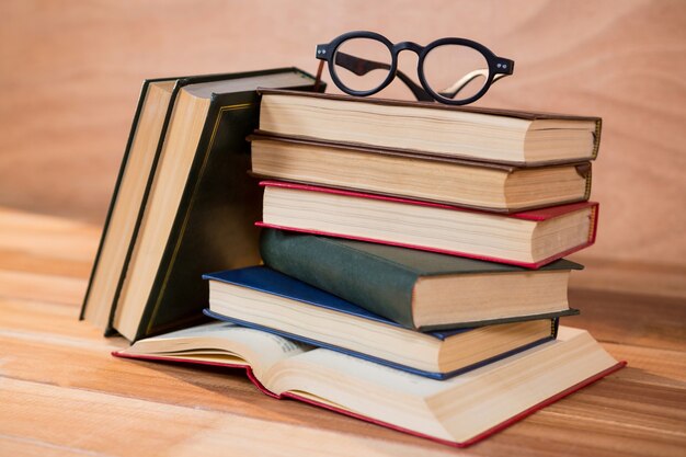Различные книги с очками на столе