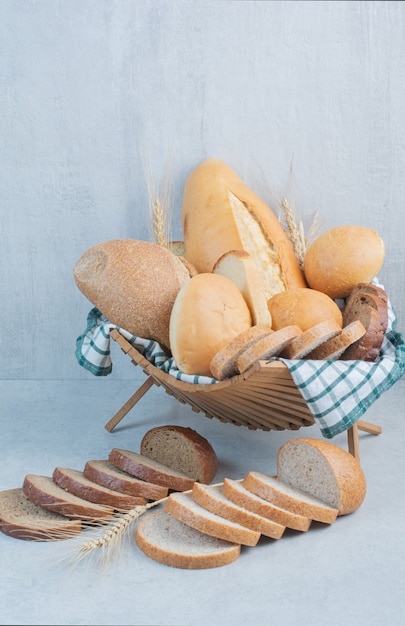 Various bread in basket on marble background. High quality photo