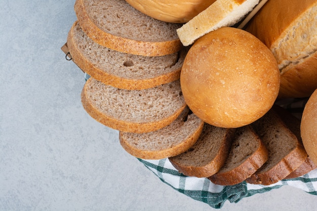 Various bread in basket on marble background. High quality photo