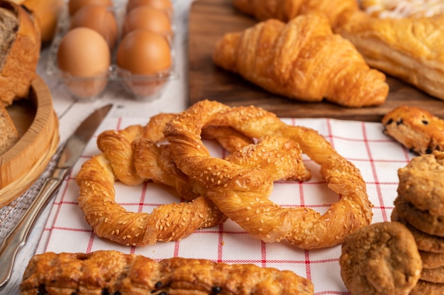 Various breads and eggs on red white cloth.