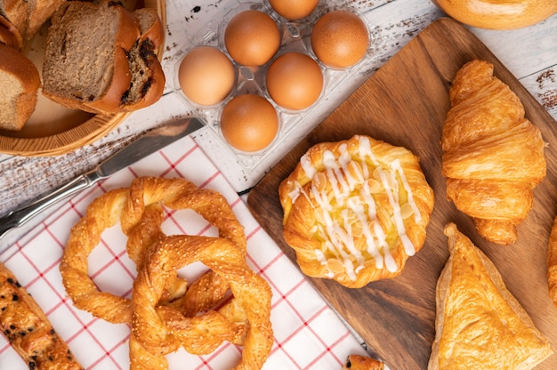 Various breads and eggs on red white cloth.