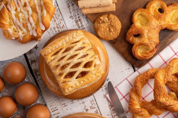 Various breads and eggs on red white cloth.