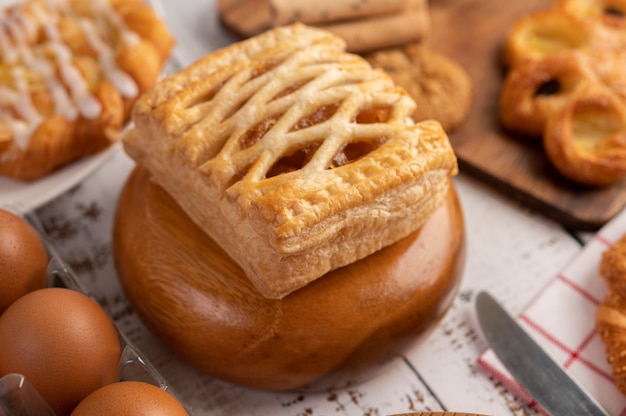 Various breads and eggs on red white cloth.