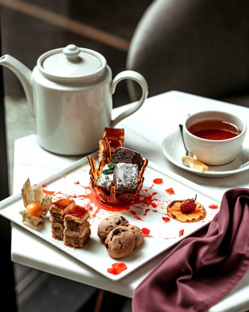 Various cakes and glass of black tea