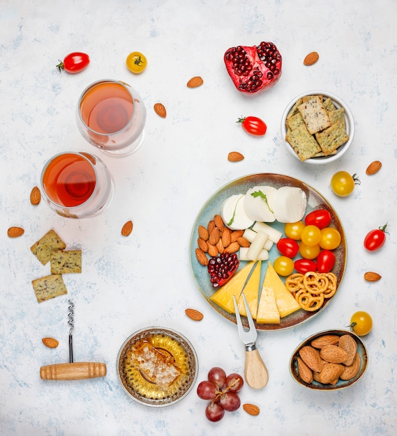 Various cheese and cheese plate on light table with different nuts and fruits