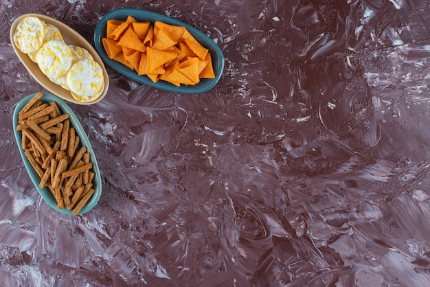 Various chips in bowls , on the marble table. 