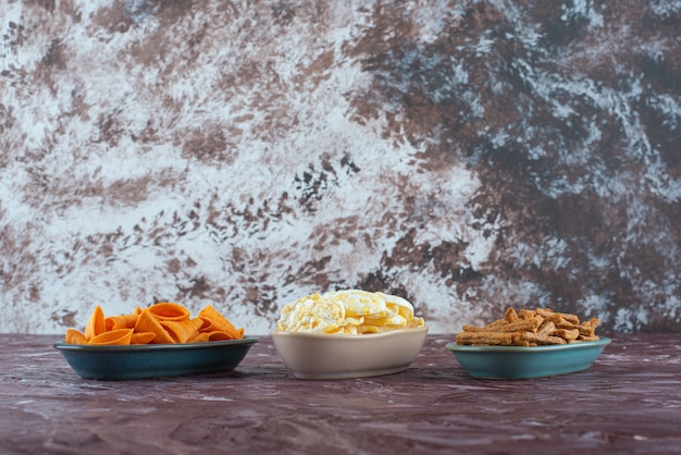 Free photo various chips in bowls , on the marble table.