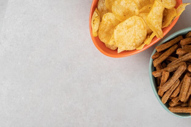 Various chips and crackers in colorful bowls