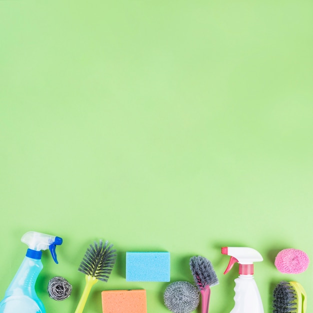 Various cleaning products at the edge of green backdrop