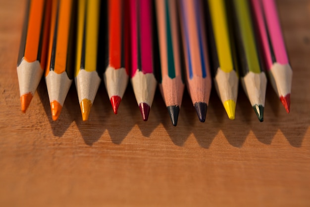 Различные цветные карандаши на деревянный стол