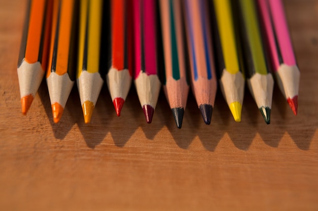 Various color pencils on wooden table