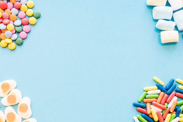 Various colorful candies on the blue background corners