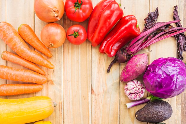 Various colorful fresh vegetables on wooden backdrop