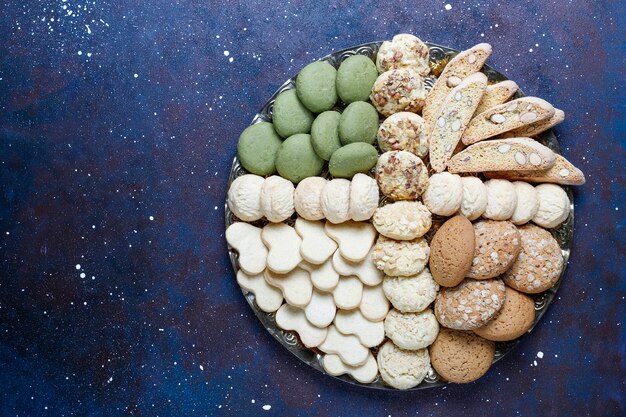 Various cookies in a wooden tray on gray background