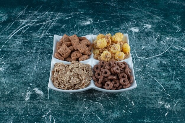 Various corn flakes in a bowl, on the blue background. High quality photo