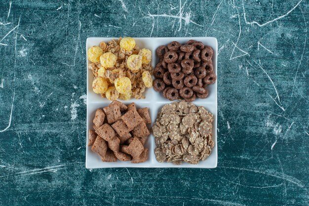 Various corn flakes in a bowl, on the blue background. High quality photo