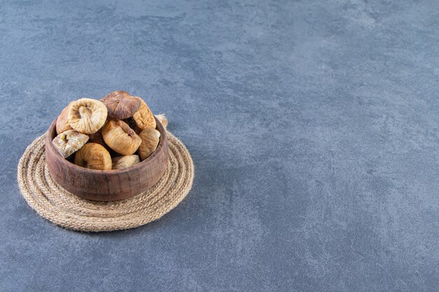 Foto gratuita vari frutti secchi in una ciotola su un sottopentola sulla superficie di marmo