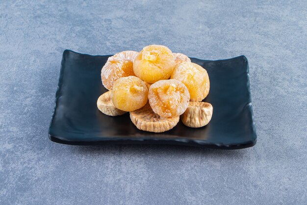 Various dried fruits in a bowl on a trivet on the marble surface