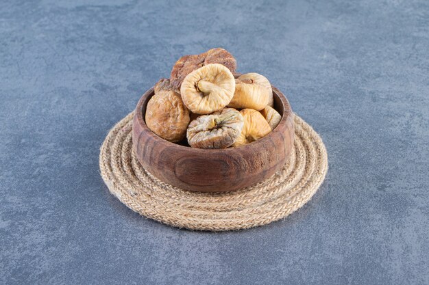 Various dried fruits in a bowl on a trivet on the marble surface