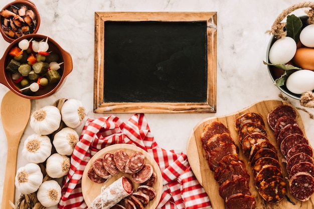 Various food near blackboard on marble table