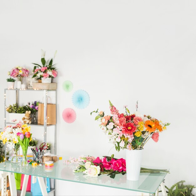 Various fresh flowers on glass desk in floral shop