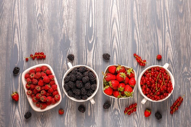 Различные свежие летние ягоды, черника, красная смородина, клубника, ежевика, вид сверху.