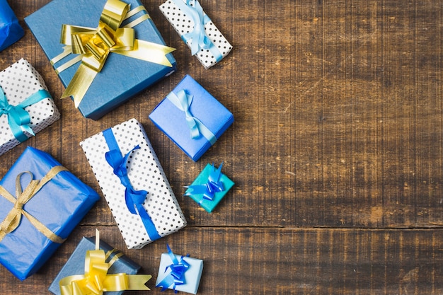 Various gift boxed wrapped and decorated with ribbons over old weathered table