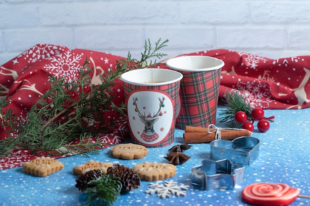 Various gingerbread cookies, cups of aroma coffee and ornaments on blue winter background. High quality photo