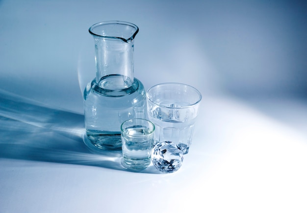 Various glass material containers with shiny diamond on blue background