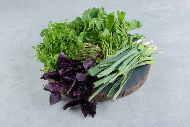 Various green vegetables on the board , on the marble