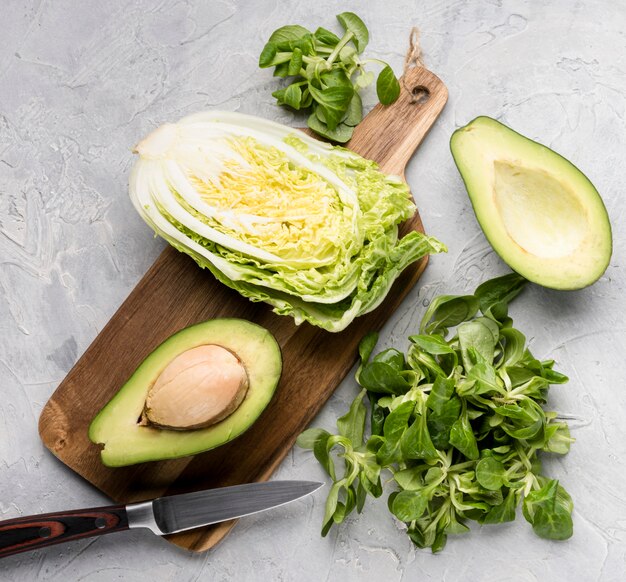 Various green veggies on cutting board