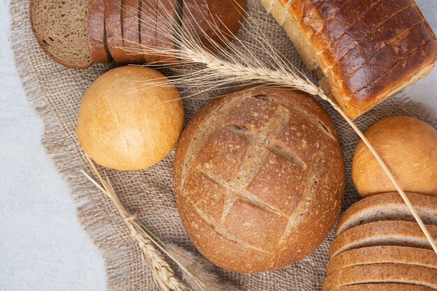 Various homemade bread on burlap with wheat. High quality photo