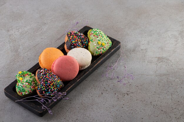 Various kinds of cookies on wooden board over grey surface