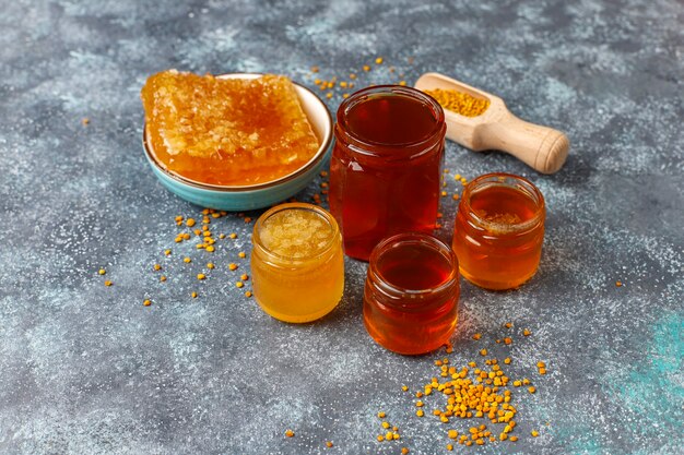 Various kinds of honey in glass jars,honeycomb and pollen.