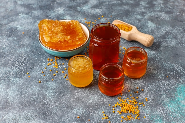 Various kinds of honey in glass jars,honeycomb and pollen.